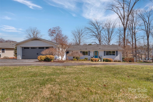 single story home with a garage, a front lawn, and driveway