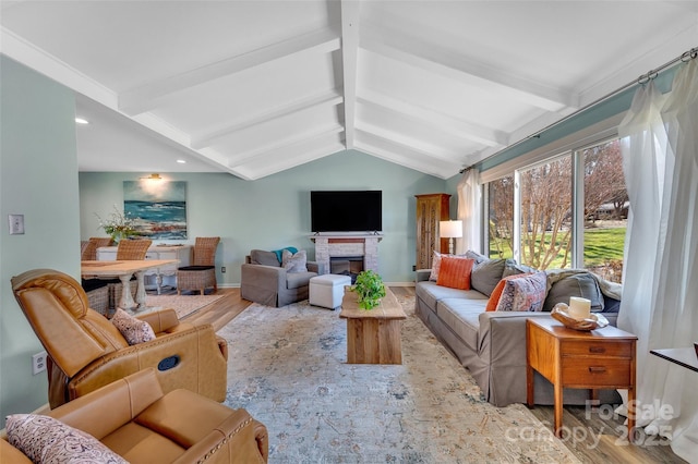 living room with lofted ceiling with beams, baseboards, wood finished floors, and a fireplace