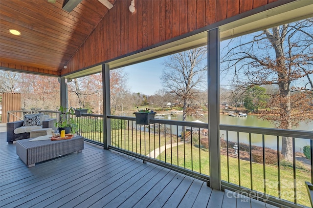 wooden deck featuring a lawn and a water view