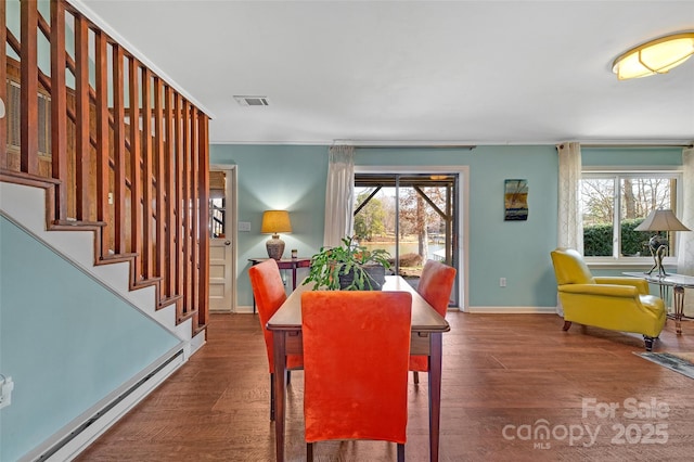 dining space with plenty of natural light, wood finished floors, visible vents, and a baseboard radiator