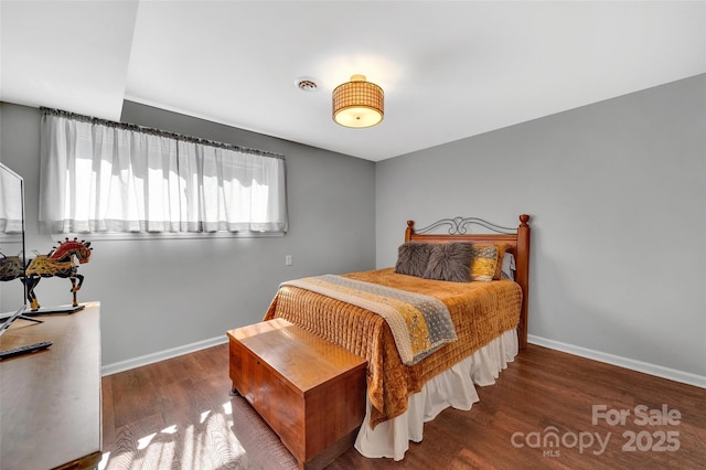 bedroom with wood finished floors, visible vents, and baseboards