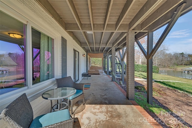 view of patio featuring stairway and a water view