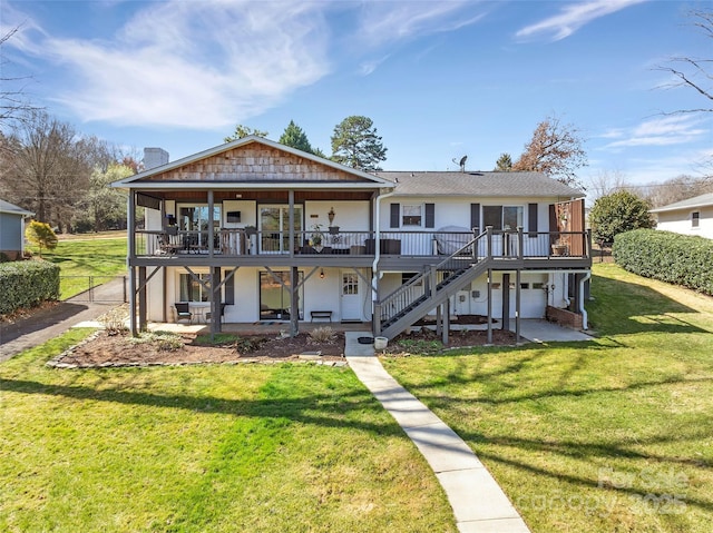 back of property featuring stairs, a patio, a yard, and a wooden deck