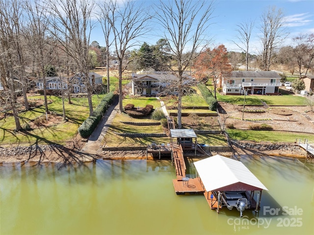 dock area with a yard, a water view, and boat lift