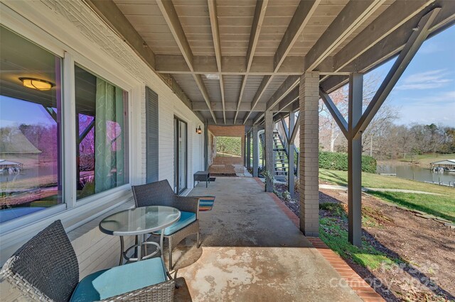 view of patio / terrace featuring stairway and a water view