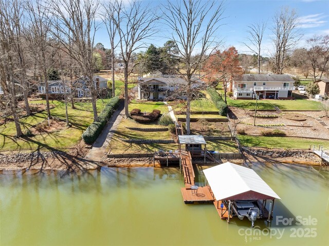 dock area with a lawn, a water view, and boat lift