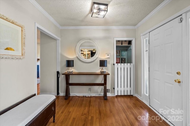 entrance foyer with crown molding, a textured ceiling, and light wood-type flooring