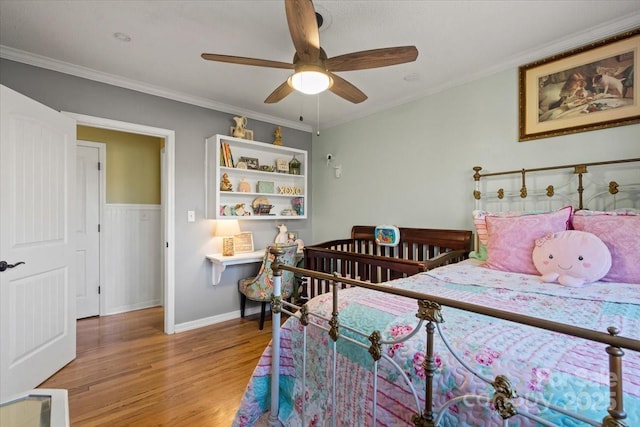 bedroom with baseboards, light wood-style floors, ornamental molding, and a ceiling fan