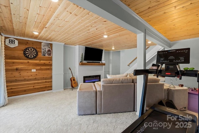 carpeted living room featuring a glass covered fireplace, recessed lighting, wooden ceiling, and stairs