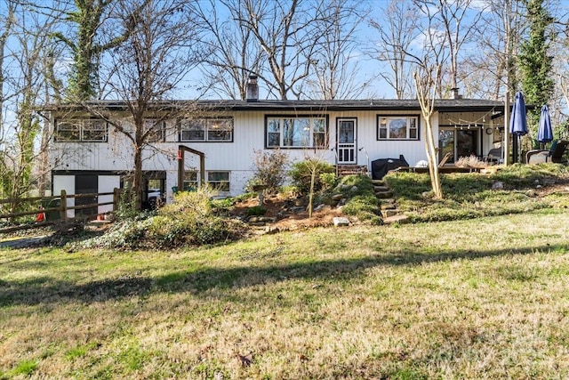 view of front of property featuring a chimney, a front yard, and fence