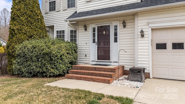 property entrance with a garage and a shingled roof