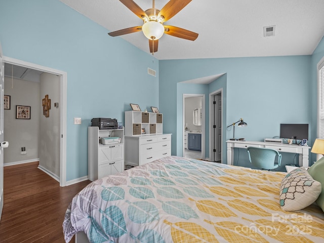 bedroom with visible vents, attic access, lofted ceiling, and wood finished floors