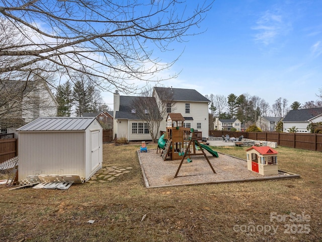 exterior space with fence, a shed, a yard, an outdoor structure, and a playground