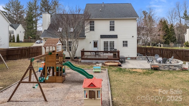 rear view of house with a yard, a patio, a fenced backyard, and a playground