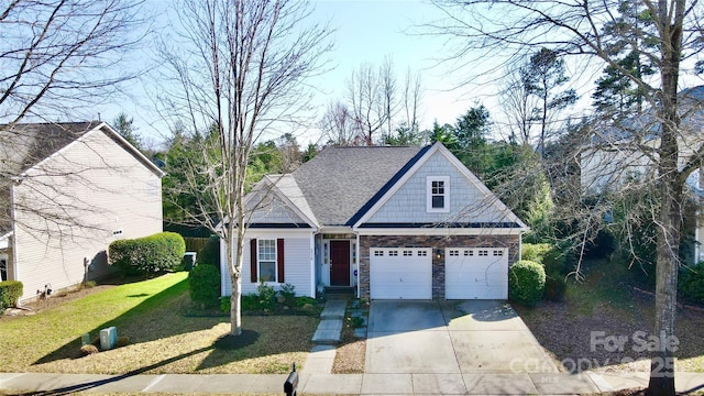 view of front of home with a front yard, driveway, roof with shingles, stone siding, and a garage