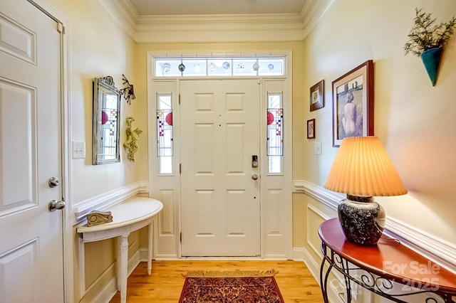 foyer with crown molding, light wood-style floors, and a healthy amount of sunlight