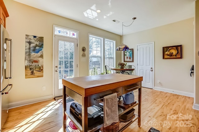 dining room featuring visible vents, light wood-style floors, and baseboards