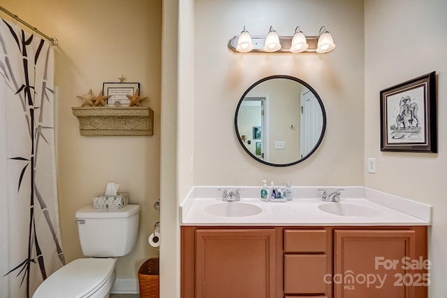 bathroom with double vanity, toilet, and a sink