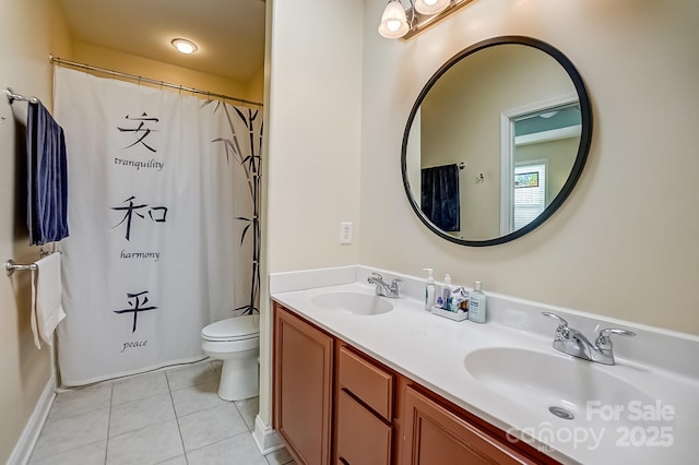 full bath with tile patterned floors, double vanity, toilet, and a sink