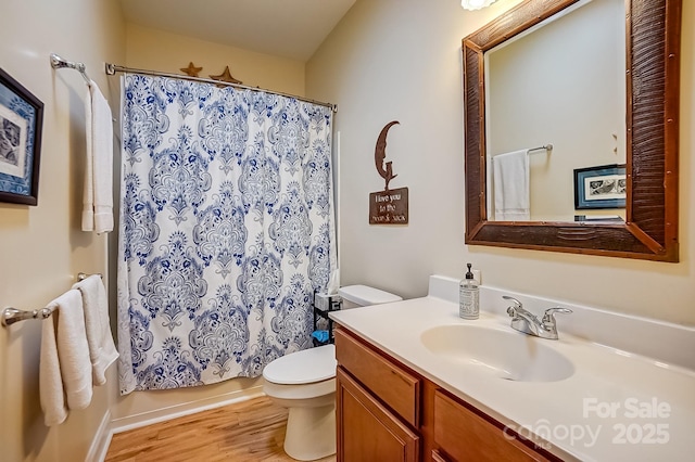 bathroom with a shower with shower curtain, toilet, wood finished floors, and vanity