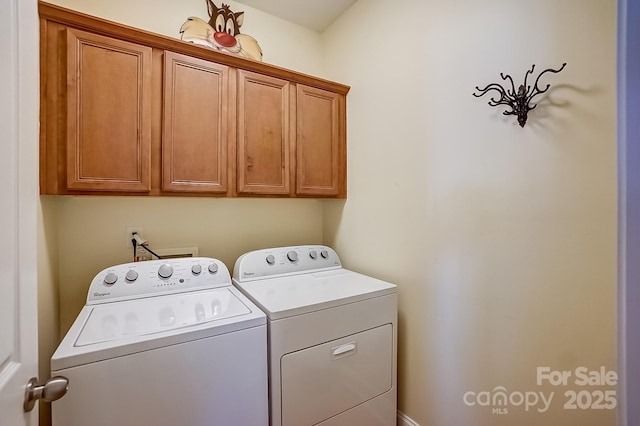 clothes washing area featuring cabinet space and washer and dryer