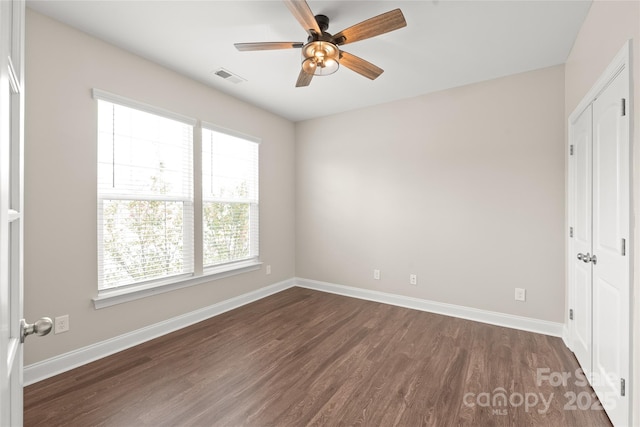 unfurnished bedroom with visible vents, baseboards, and dark wood-type flooring