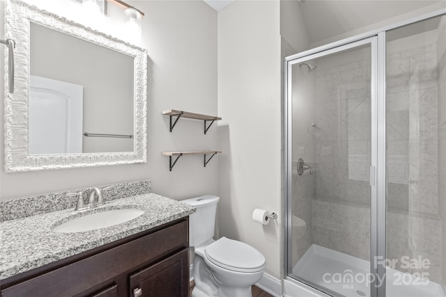 full bath with vanity, toilet, and a shower stall