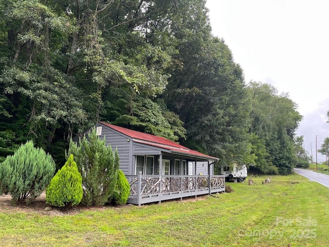 view of front of home featuring a front lawn and metal roof