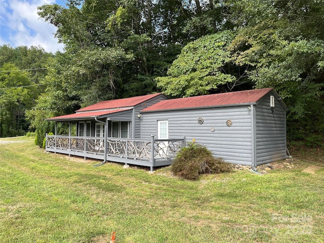 view of front of property with metal roof and a front yard