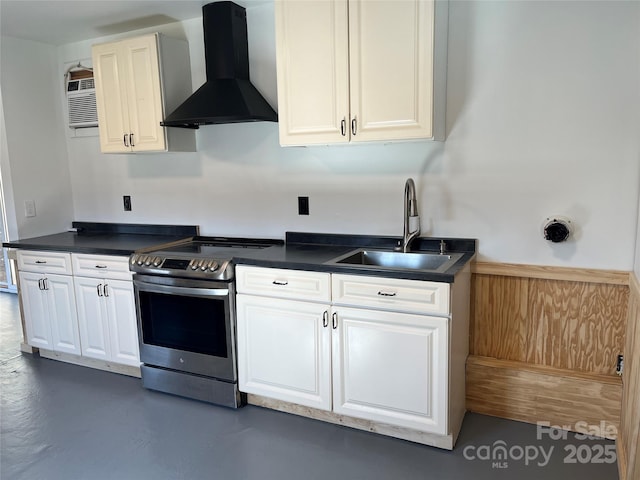 kitchen with electric stove, a sink, dark countertops, white cabinetry, and wall chimney exhaust hood