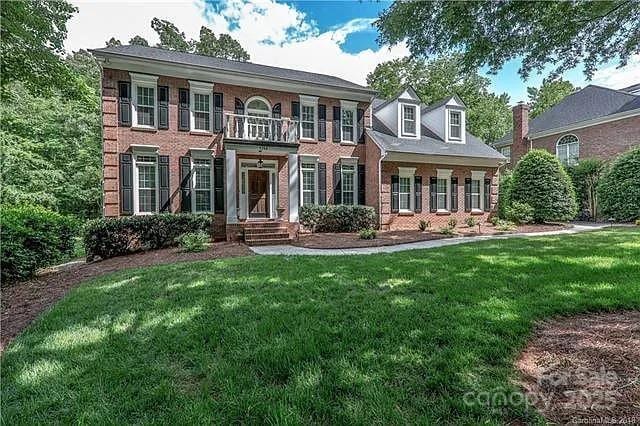 view of front of property featuring brick siding and a front lawn