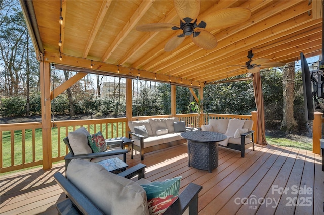 wooden terrace featuring an outdoor hangout area and a ceiling fan