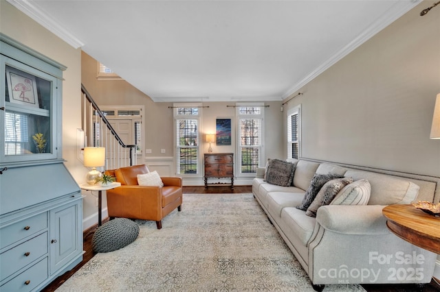 living area with stairway, ornamental molding, and wood finished floors