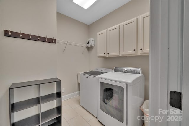 laundry area with light tile patterned floors, cabinet space, baseboards, and washing machine and clothes dryer