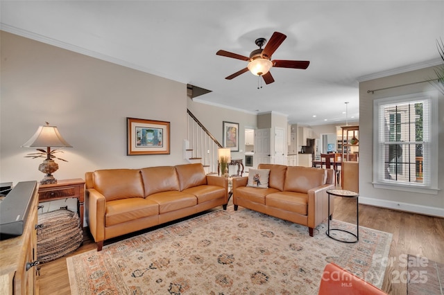 living area featuring stairway, wood finished floors, and ornamental molding