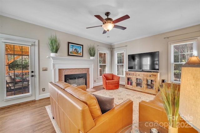 living room featuring ceiling fan, plenty of natural light, wood finished floors, and a fireplace