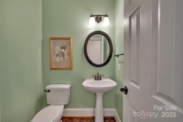 bathroom featuring toilet and baseboards