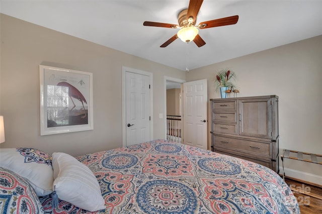 bedroom featuring baseboards, ceiling fan, and wood finished floors