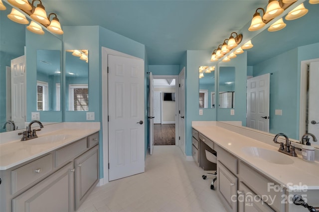 bathroom featuring a chandelier, two vanities, and a sink