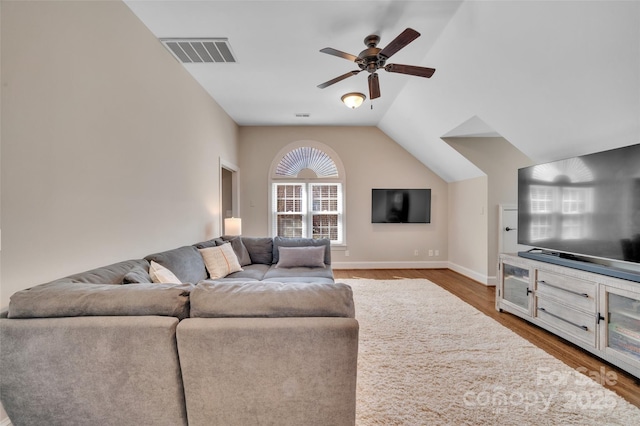 living room featuring visible vents, lofted ceiling, wood finished floors, and a ceiling fan