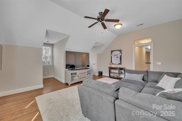 living room featuring visible vents, baseboards, vaulted ceiling, light wood-style floors, and a ceiling fan