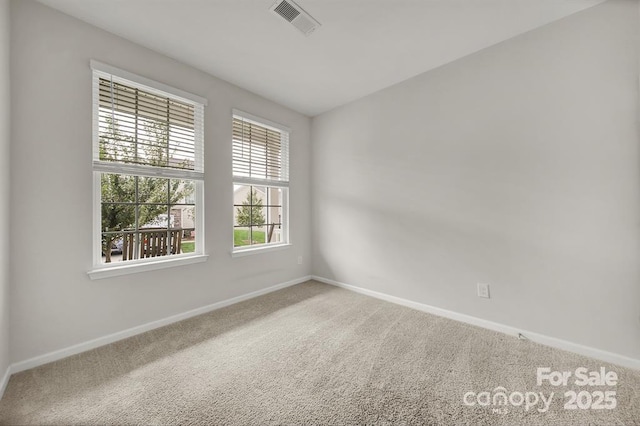 carpeted spare room with visible vents and baseboards