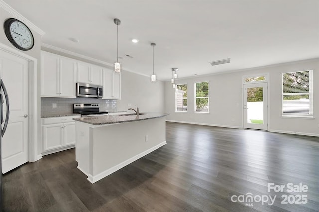 kitchen featuring visible vents, backsplash, stainless steel appliances, white cabinets, and light stone countertops