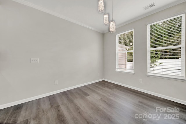 spare room featuring crown molding, visible vents, baseboards, and dark wood-style flooring