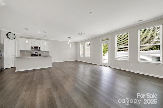 unfurnished living room featuring visible vents, baseboards, ornamental molding, and dark wood-style flooring