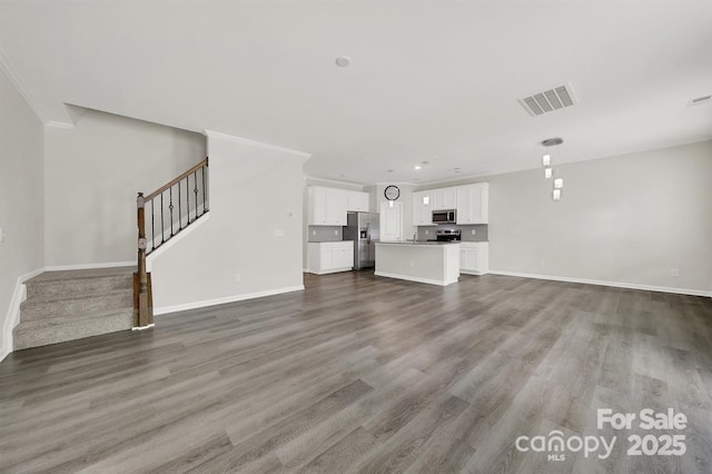 unfurnished living room with stairway, baseboards, visible vents, and wood finished floors