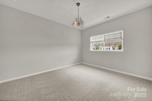 spare room featuring visible vents, a notable chandelier, carpet flooring, baseboards, and vaulted ceiling