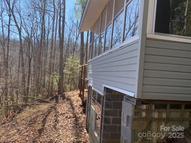 view of property exterior featuring a forest view