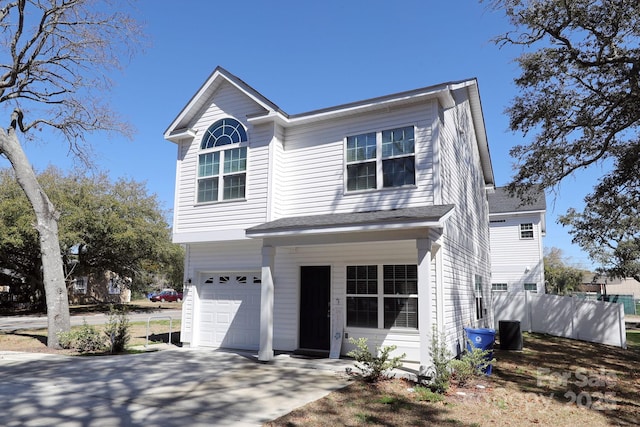 traditional-style house featuring central air condition unit, driveway, and an attached garage