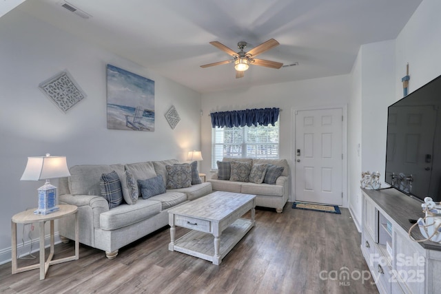 living room featuring visible vents, baseboards, ceiling fan, and wood finished floors